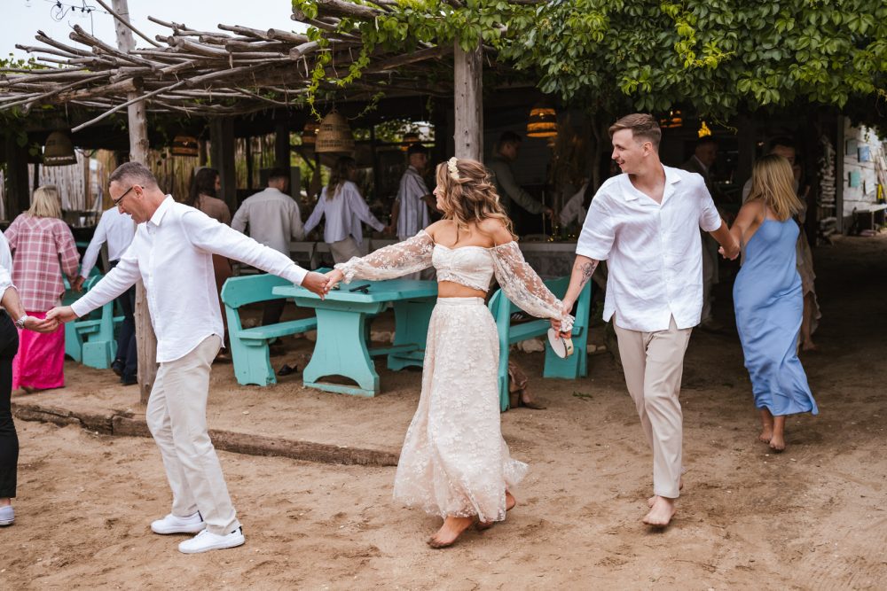 Bride and groom dancing barefoot in the sand at Levan Island Istria