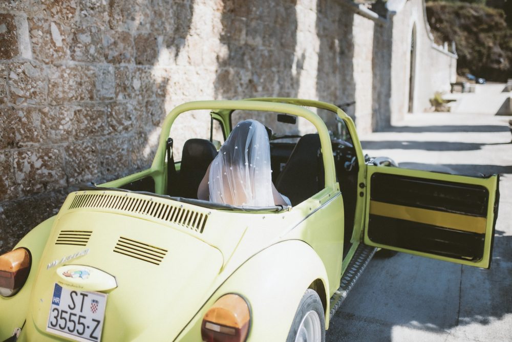 Bride arriving to the wedding ceremony in a yellow Beetle car