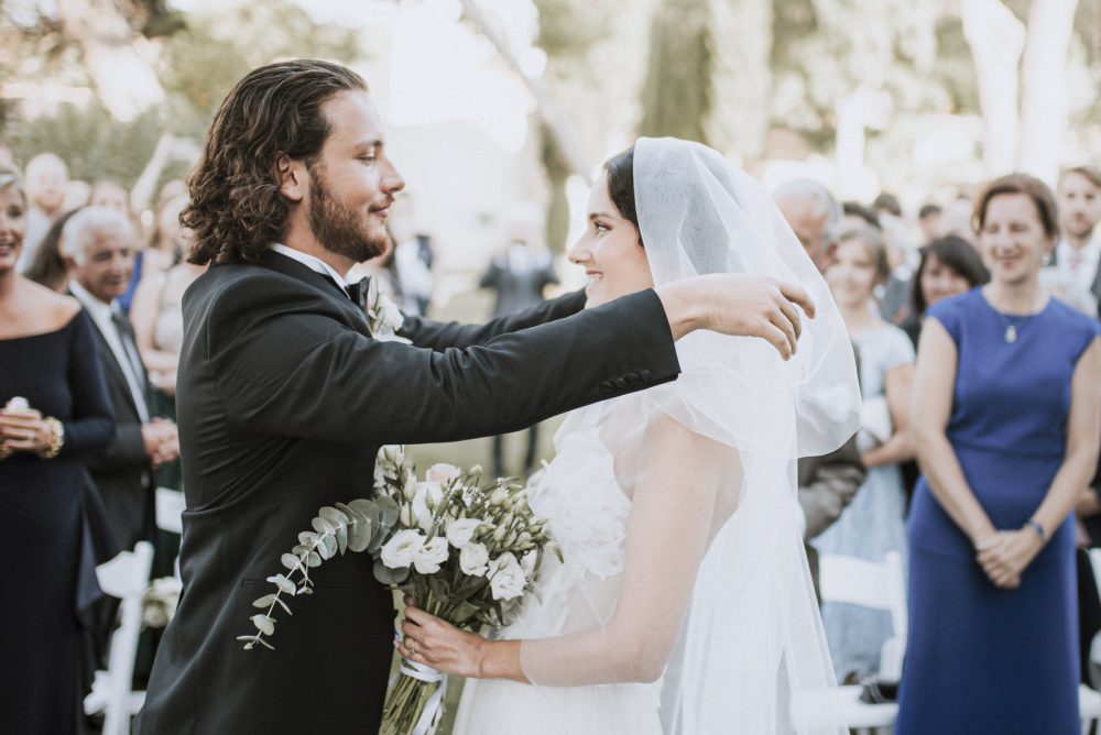 Groom lifting the bride’s veil during a heartfelt wedding ceremony at Martinis Marchi on Solta Island