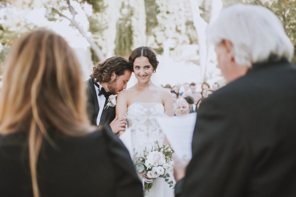 Bride and groom exchanging vows during a black-tie wedding ceremony at Martinis Marchi