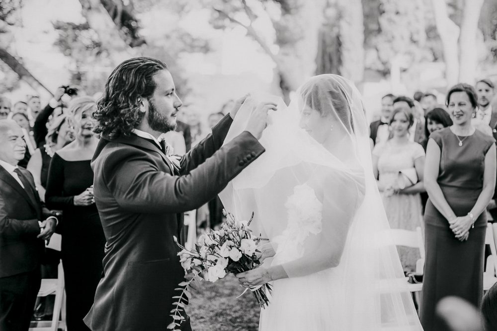 Groom lifting the bride’s veil during a heartfelt wedding ceremony at Martinis Marchi on Solta Island
